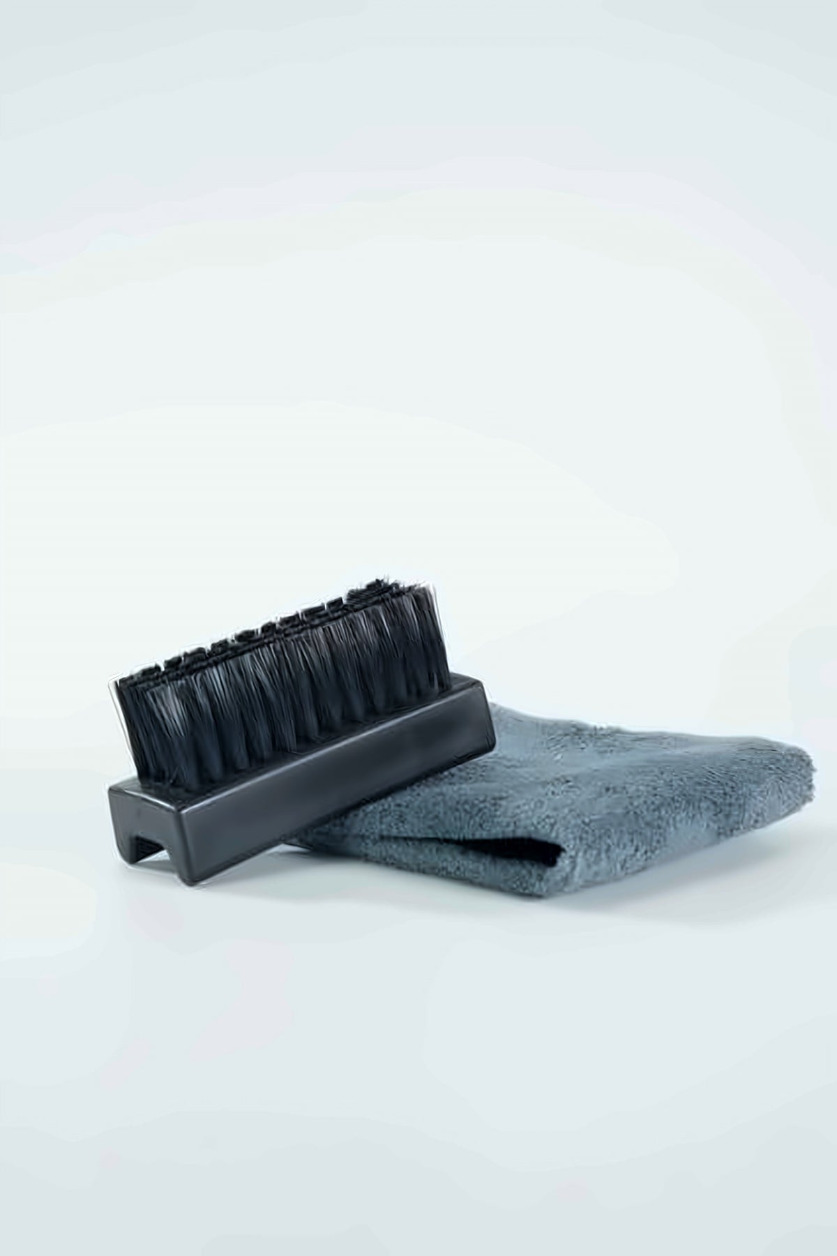 KIXCURE cleaning brush resting on the ultra-soft microfiber towel